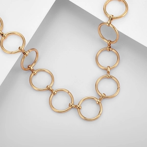 Gros plan détaillé d'un collier doré à grands cercles géométriques avec finition métallique