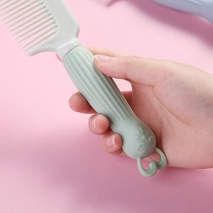 Lindo peine para el cabello de conejo verde menta para niños sobre un fondo rosa suave.