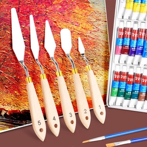 Detailed set of 5 stainless steel palette knives with wooden handles and oil paint tubes