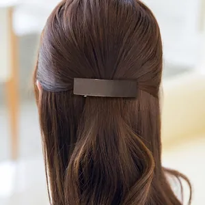 Pince à cheveux rectangulaire marron foncé mat sur une coiffure demi-haute