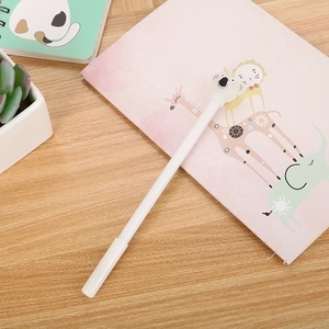 Cute white cartoon koala gel ink pen on a wooden table with a pink animal notebook