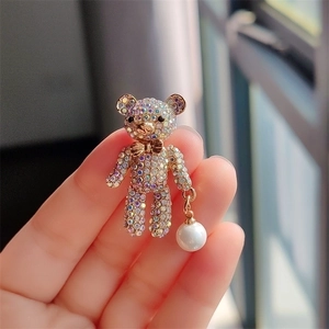 Fashionable golden bear brooch with colorful rhinestones and a white pearl drop detail