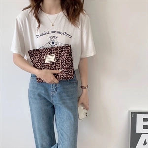 Fashionable leopard print canvas makeup bag held by a model in casual white t-shirt