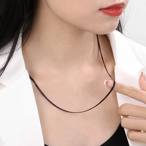 Minimalist black titanium steel snake bone chain necklace shown on a female model neck
