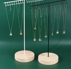Detail of T-shaped iron necklace stands in black and white with solid wood bases