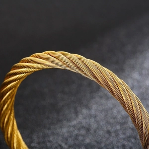 Macro shot of gold punk style twisted wire texture on a stainless steel open cuff bracelet