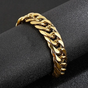 Close-up of golden stainless steel Cuban link bracelet on a textured black surface