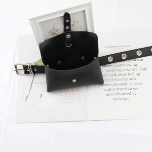 Detailed view of black leather waist bag with silver metal eyelets and snap closure