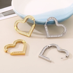 Detail of gold and silver heart-shaped hoop earrings with micro-inlaid cubic zirconia
