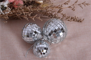 Silver mirror disco balls in various sizes on burlap background with dried flowers