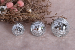 Close-up of three silver mirror disco balls in different sizes with hanging strings