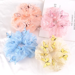 Mesh butterfly scrunchies set in pink, blue, beige, and orange on white fabric
