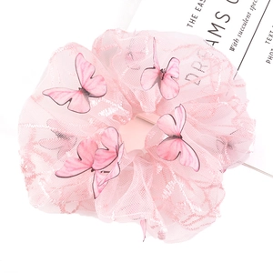 Detail of pink mesh scrunchie featuring realistic butterfly wings on white background