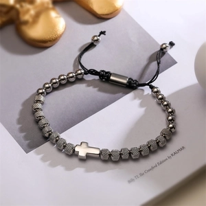 Detail of silver beads bracelet with cross pendant and adjustable black string cord