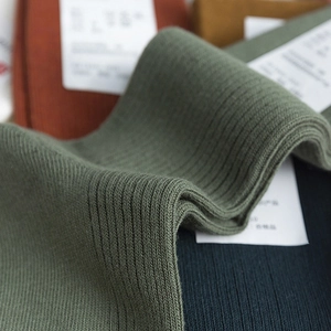 Stack of Japanese retro cotton crew socks in dark green and various rib-knit solid colors