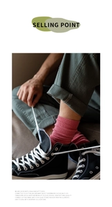 Detail of pink cotton crew socks with vertical stripes worn with black high-top canvas shoes