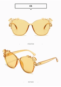 Detailed view of amber cat eye sunglasses with rhinestones and crystal flower accents