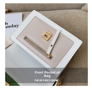 Detail view of the front pocket and golden buckle on white and pink leather bag