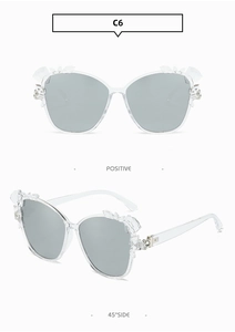 Detail of floral accents on transparent oversized sunglasses frame in C6 colorway