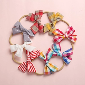Detail of 8-piece baby headband set with assorted patterns on soft pink background