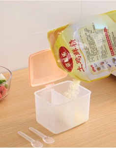 Close-up of dual-compartment kitchen spice box with spoons and transparent matte body
