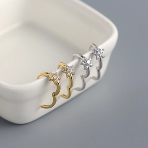 Close-up of gold and silver S925 sterling silver star earrings with sparkling zircons