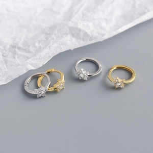 Macro shot of minimalist S925 silver star earrings with gold and silver cubic zirconia