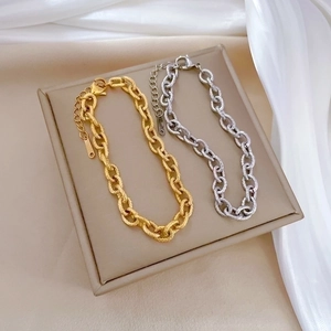 Minimalist vintage chain bracelets in gold and silver steel finishes shown on silk