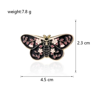 Detail of butterfly enamel brooch with pink flowers and measurements 4.5cm by 2.3cm