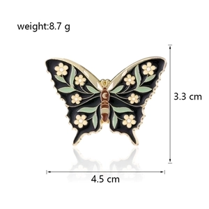 Detailed macro view of enamel butterfly brooch with floral patterns and lunar motif