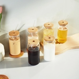 Set of six can-shaped glass cups with bamboo lids and glass straws for cold drinks