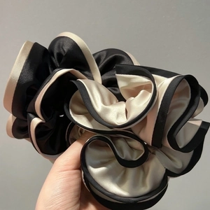 Elegant oversized black and white satin scrunchie with contrast stitching for ponytails