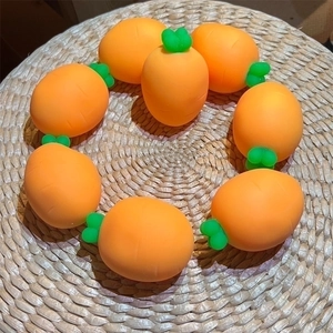 Set of seven bright orange squishy carrot toys on a woven mat for stress relief