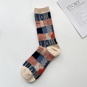 Detail of vintage plaid cotton sock in beige, navy, and red with a stylish retro pattern
