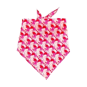 Detailed close-up of pink pet bandana with romantic red heart patterns and neat stitching