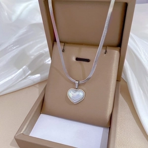 Silver titanium steel necklace with heart pearl pendant on white satin background
