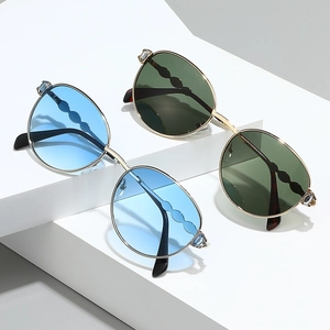 Lunettes de soleil rondes en métal de luxe avec strass et verres dégradés, vue latérale