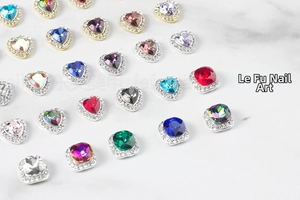 Close-up of mixed heart and square crystal nail art rhinestones on marble surface