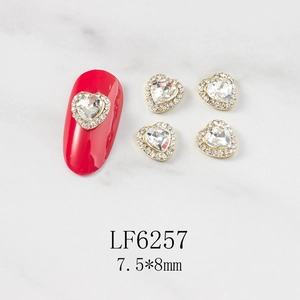3D heart nail charms with gold metal base and clear rhinestones on red nail model