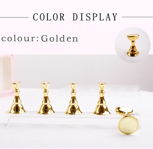 Detail of golden chess-piece nail art stands on a clear acrylic display base