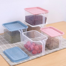 Close-up of clear plastic food storage jars with colorful handles and wavy textured lids