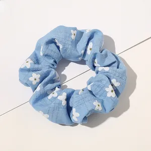 Close-up of light blue floral plaid scrunchie with natural pleats and cotton fabric texture