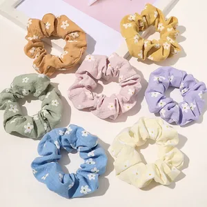 Set of seven floral plaid fabric scrunchies in pastel colors for ponytail styling