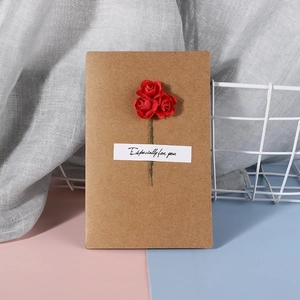 Detail view of handmade kraft paper card with red paper roses and especially for you text