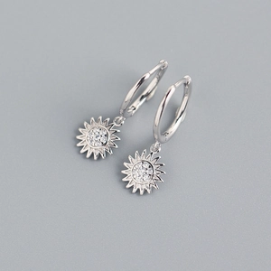 Detailed view of silver sunflower earrings with clear sparkling crystals on gray background