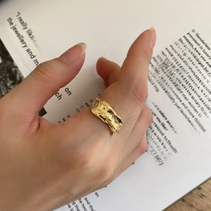 Macro detail of irregular gold lava texture on a 925 sterling silver wide ring for women
