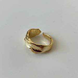 Detailed view of the irregular lava texture and gold liquid metal finish on this ring