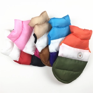 Dettaglio di gilet invernali colorati per cani impilati con logo 'BORN TO BE LOVED'