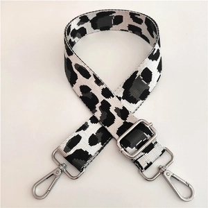 Close-up of leopard print bag strap with silver metal swivel hooks and adjustable buckle