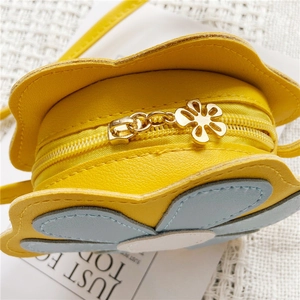 Détail du sac fleur jaune montrant le cuir synthétique et la fermeture éclair dorée